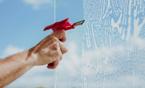 Neon Clean technician dusting window frame and sill before wet washing